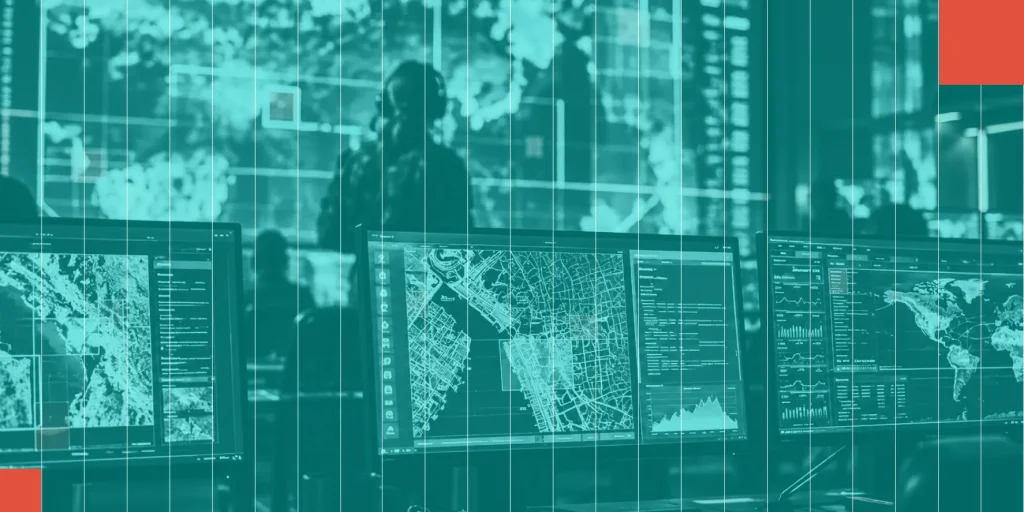 Operations center with analysts and map displays across multiple monitors